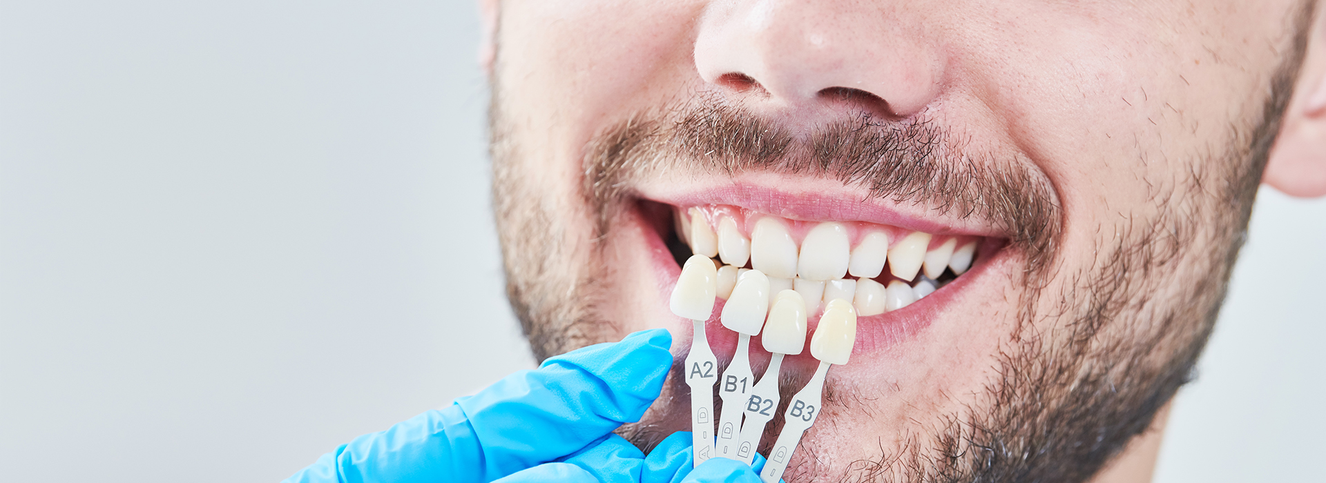 A man receiving dental treatment, with a focus on the dental tools and his smiling expression.