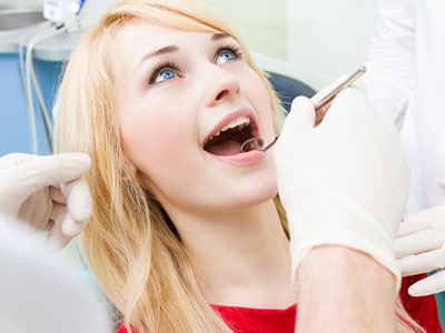 A person receiving dental care, with a dental practitioner performing an examination or procedure.